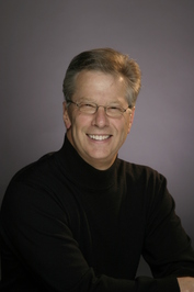 Author Allen Wyler: photo of a smiling White Male wearing a black shirt and eyeglasses