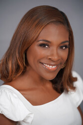 Author Sadeqa Johnson photograph featuring a smiling Black American female with shoulder-length reddish-brown hair wearing a white top with flutter-sleeves